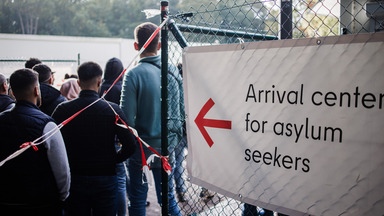 Menschen stehen Schlange vor einem Zentrum für Asylsuchende in Berlin