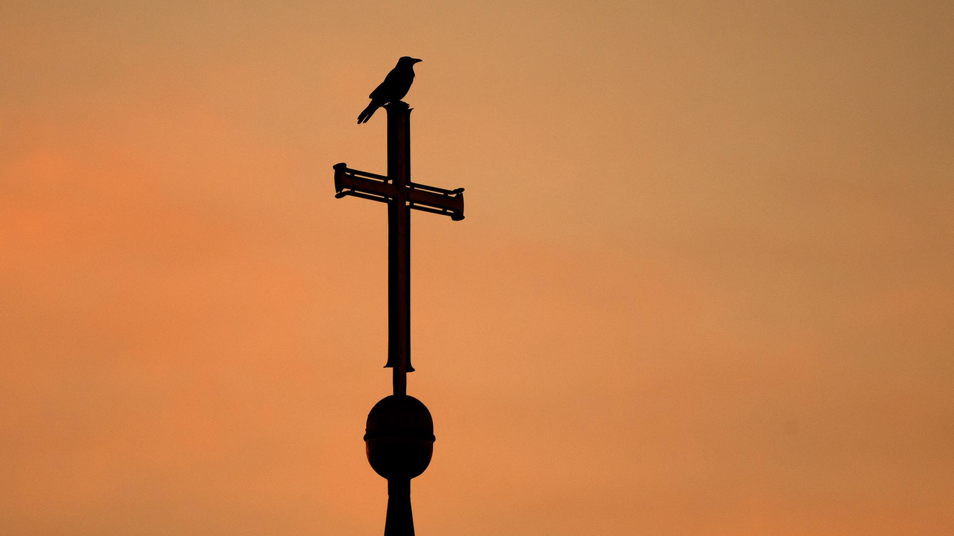 Ein Kirchenkreuz auf dem Dach einer Kirche. | dpa