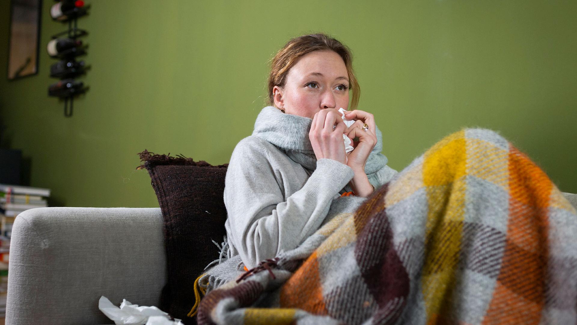 Eine Frau putzt sich die Nase. | picture alliance / Westend61