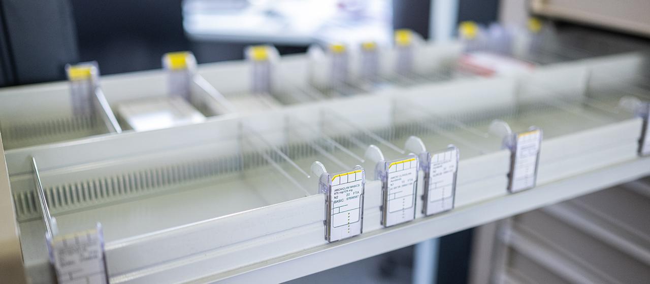 Leere Fächer einer geöffneten Medikamentenschublade in einer Apotheke.