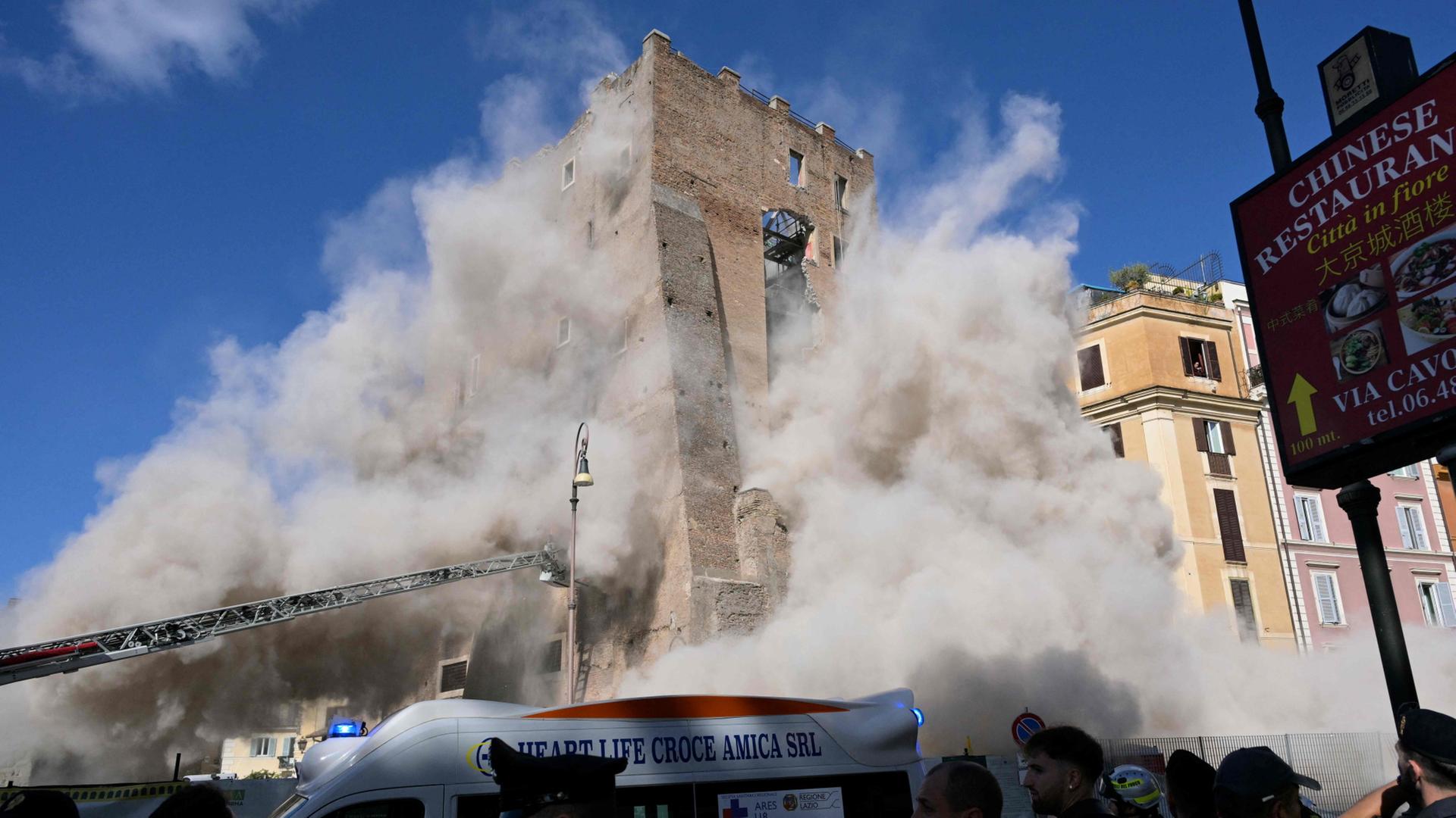 Staub steigt nach dem Einsturz eines Teils des mittelalterlichen Turms Torre dei Conti in Rom auf. | AFP