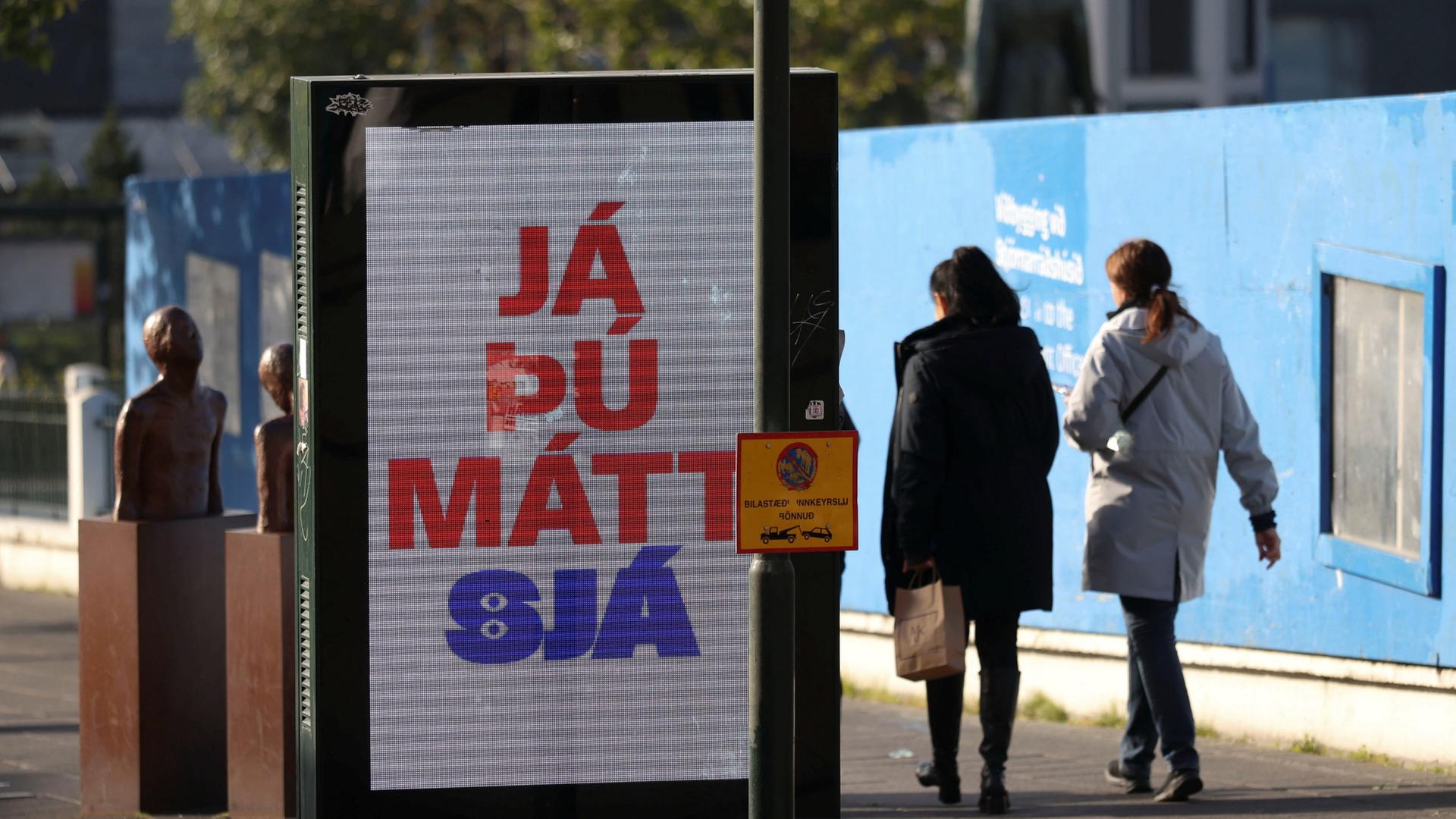 Passanten gehen in Reykjavík an einem Plakat der Befürworter der Wiederaufnahme der EU-Beitrittsverhandlungen vorbei | REUTERS