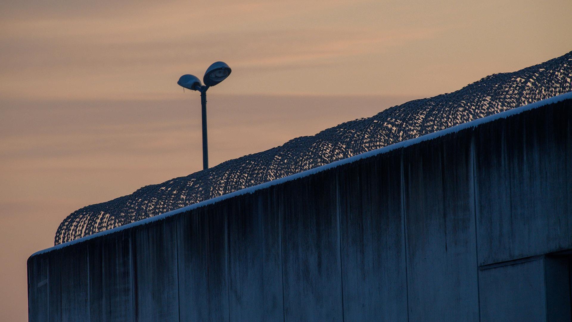 Der Tag bricht über der drahtbewährten Mauer der Justizvollzugsanstalt Burg an. | Klaus-Dietmar Gabbert/dpa