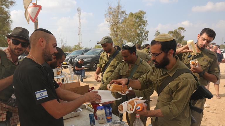 Freiwillige bei Beersheba versorgen israelische Soldaten mit Essen und Getränken.