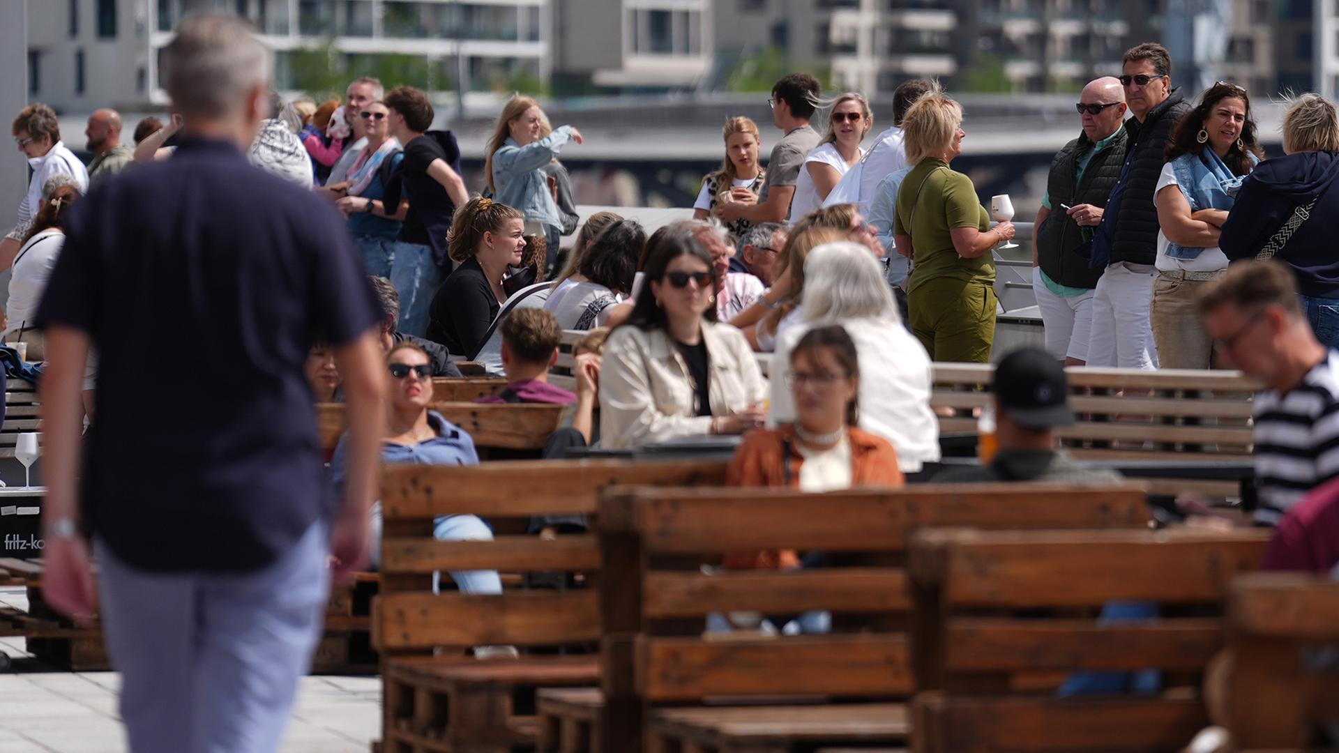 Menschen sitzen in der Sonne | dpa