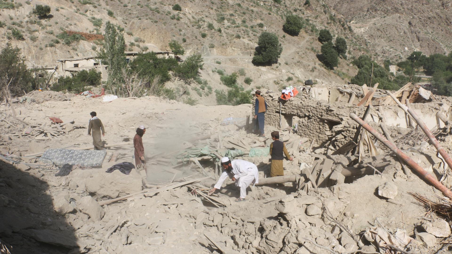 Menschen durchsuchen die Trümmer eines Hauses im Dorf Mani im Bezirk Spera in der Provinz Khost (Afghanistan). | REUTERS
