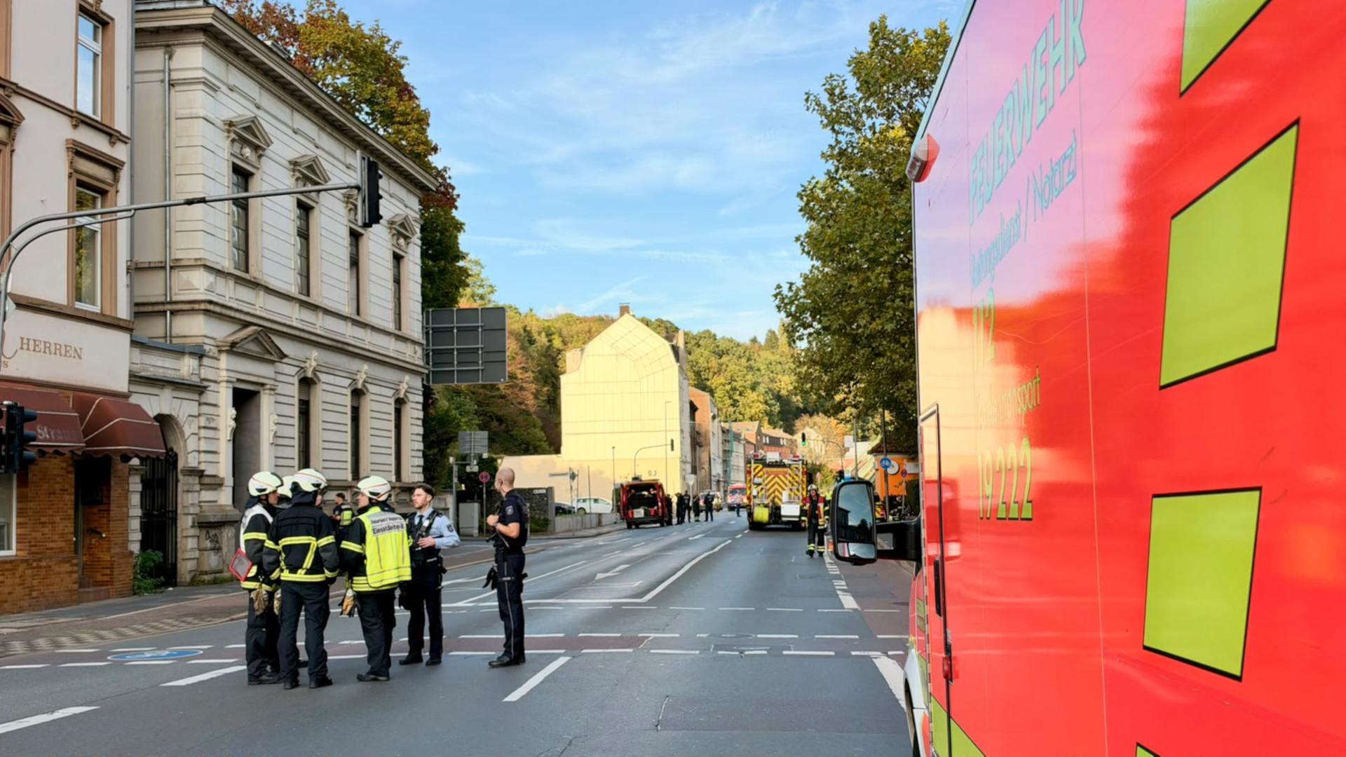 Mehrere Feuerwehrleute stehen vor einem einsturzgefährdeten Haus | Tim Oelbermann
