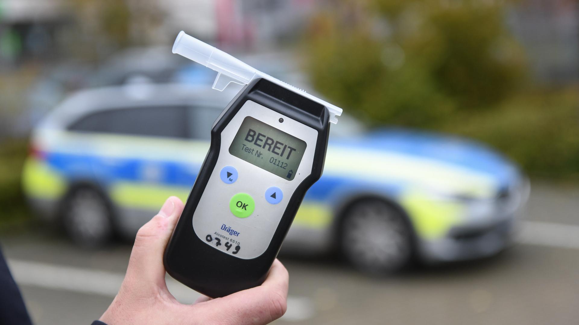 Ein Polizist misst den Atemalkoholgehalt eines Autofahrers mit einem Alkoholtester, um festzustellen, ob er möglicherweise unter Alkoholeinfluss steht. | imago