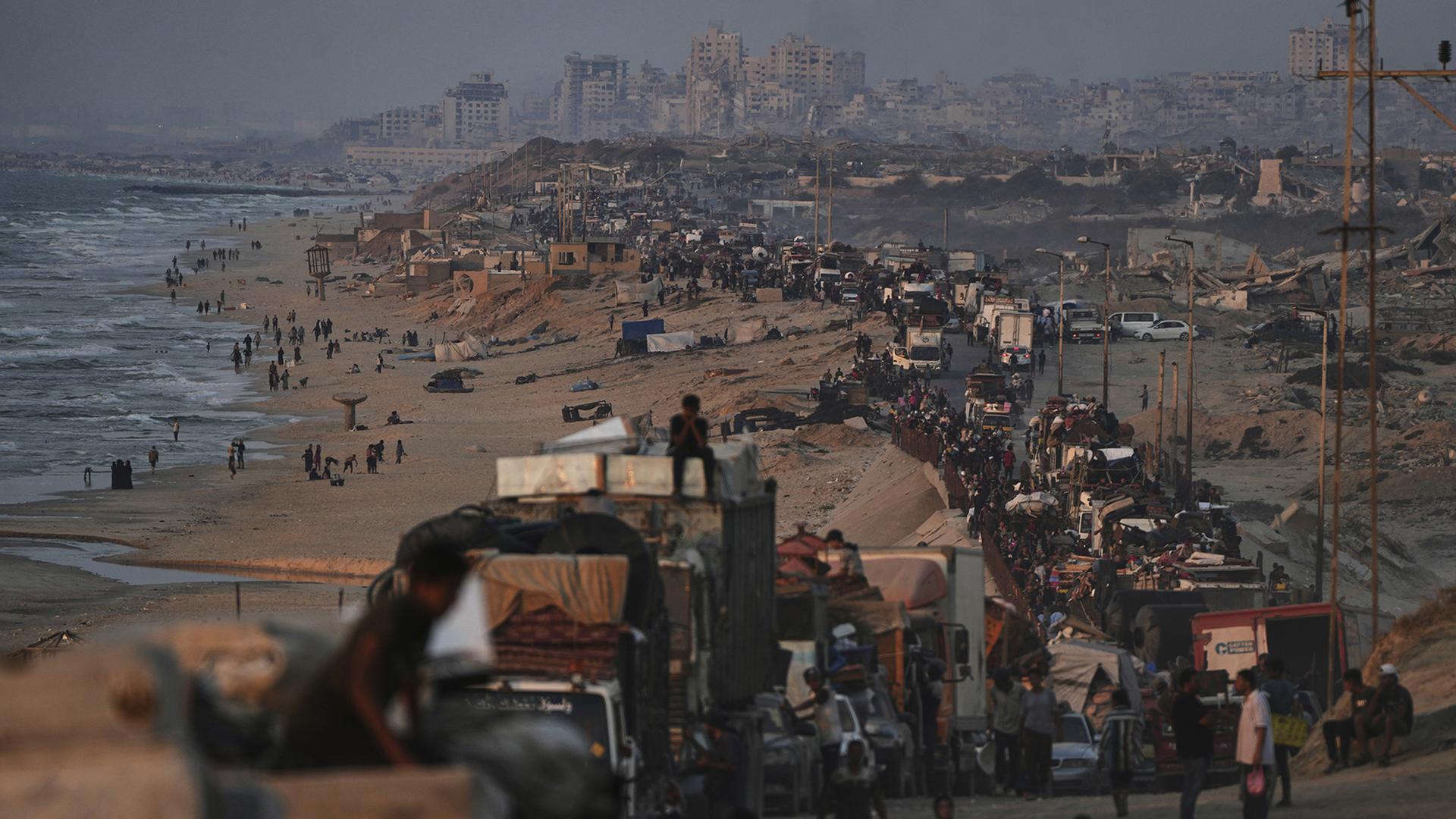 Vertriebene Palästinenser fliehen aus Gaza-Stadt und tragen ihre Habseligkeiten entlang der Küstenstraße in Richtung des südlichen Gazastreifens. | dpa
