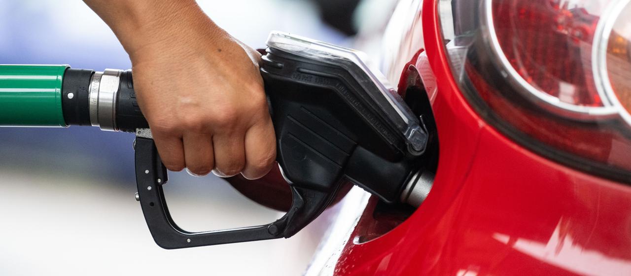 Eine Frau tankt an einer Tankstelle.