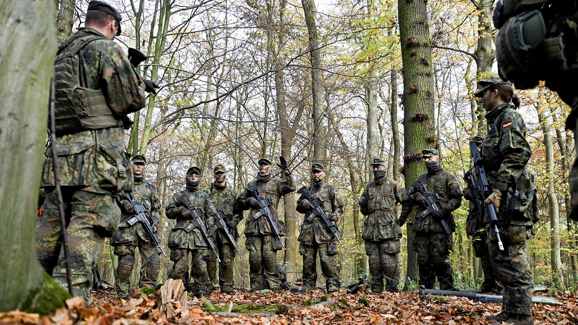 Soldaten besprechen sich in einem Wald. | dpa