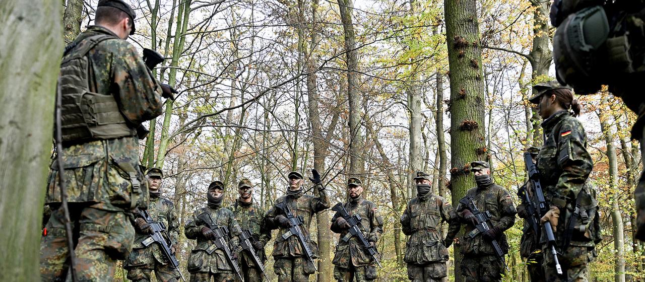 Soldaten besprechen sich in einem Wald.