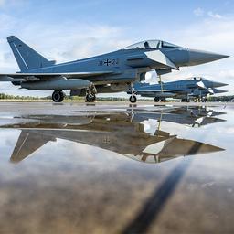 Eurofighter spiegeln sich in einer Pfütze am Flughafen Münster-Osnabrück.