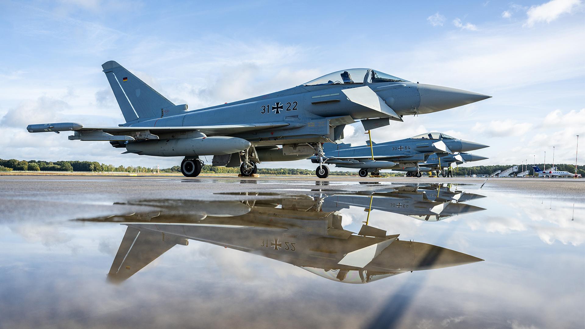 Eurofighter spiegeln sich in einer Pfütze am Flughafen Münster-Osnabrück. | dpa
