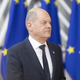 Olaf Scholz steht vor Flaggen der Europäischen Union.