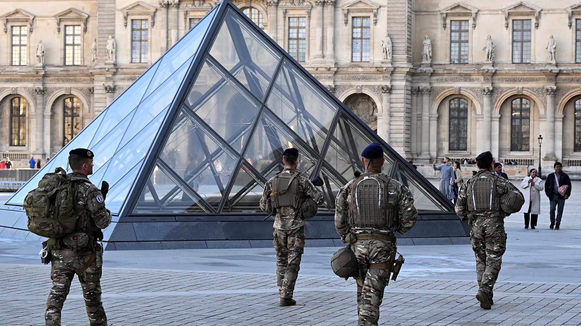 Soldaten patrollieren vor dem Louvre in Paris. | dpa