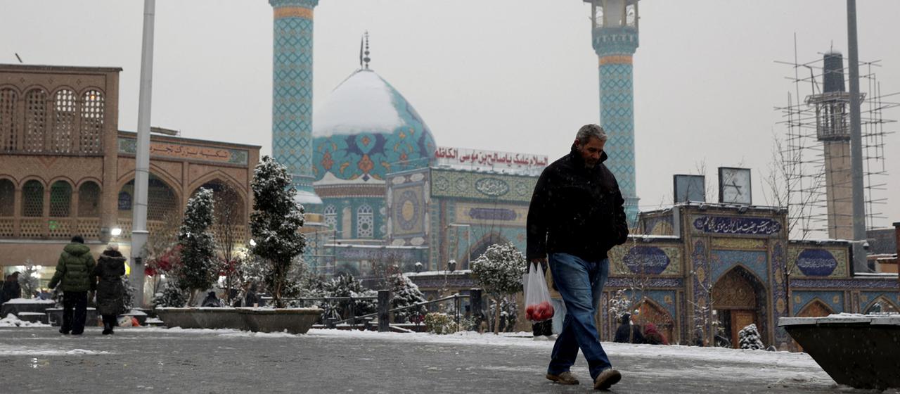 A person crosses a street in Tehran.