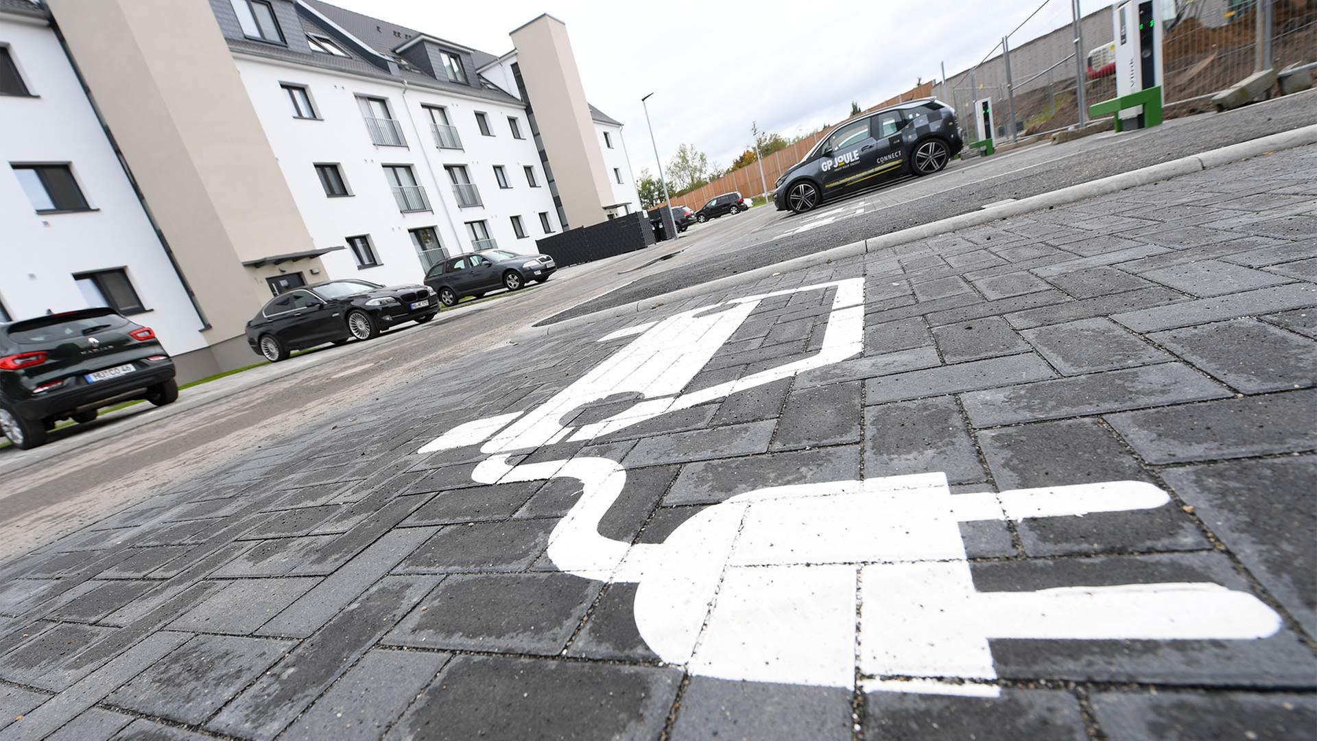 Piktogramm vor Mehrfamilienhaus weist auf LademÃ¶glichkeit fÃ¼r ein E-Auto hin. | picture alliance/dpa