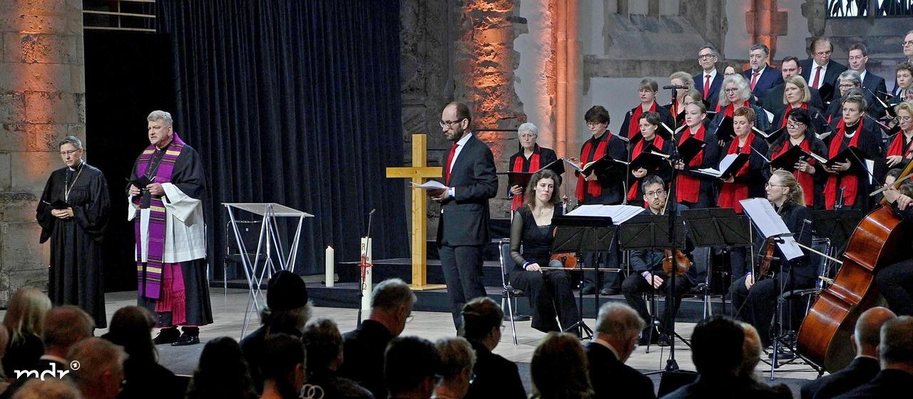 Regionalbischöfin Bettina Schlauraff und Kathedralpfarrer Daniel Rudloff sprechen zu den Teilnehmern des ökumenischen Gedenkgottesdienstes in der Johanniskirche in Magdeburg