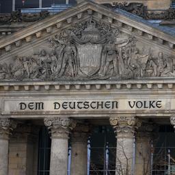 Eine deutsche Flagge weht vor dem Reichstag.