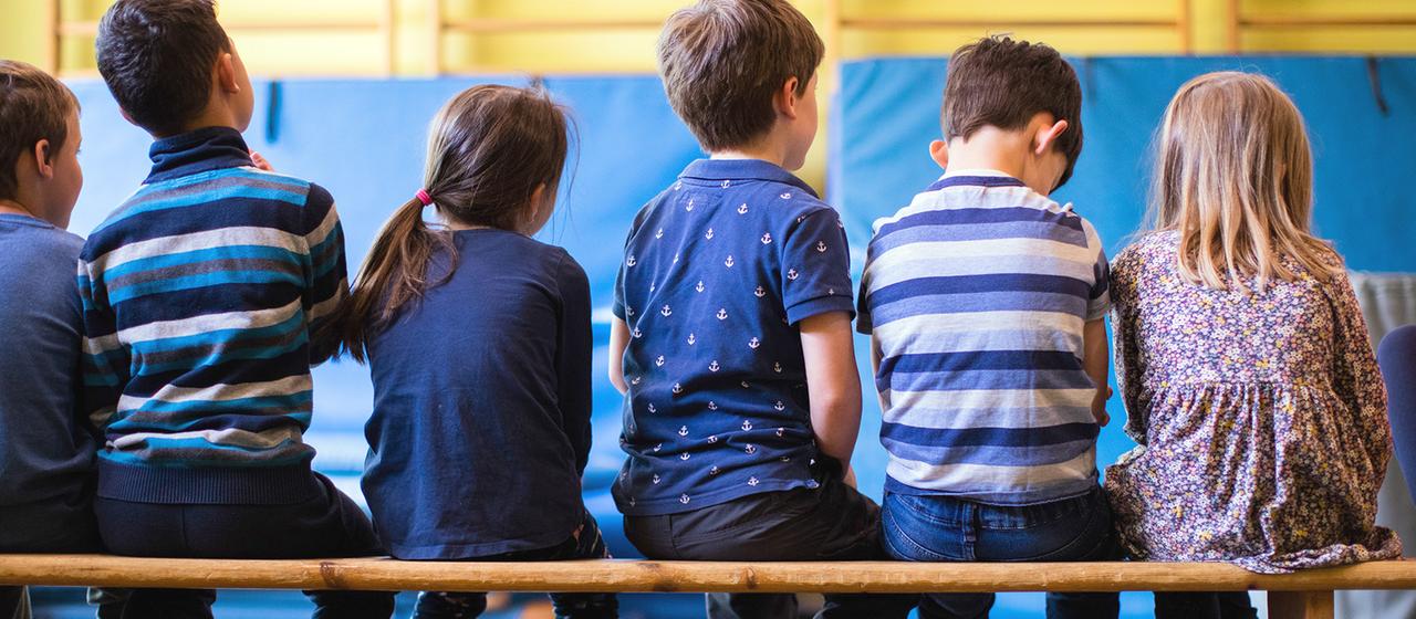 Kinder sitzen in einer Reihe