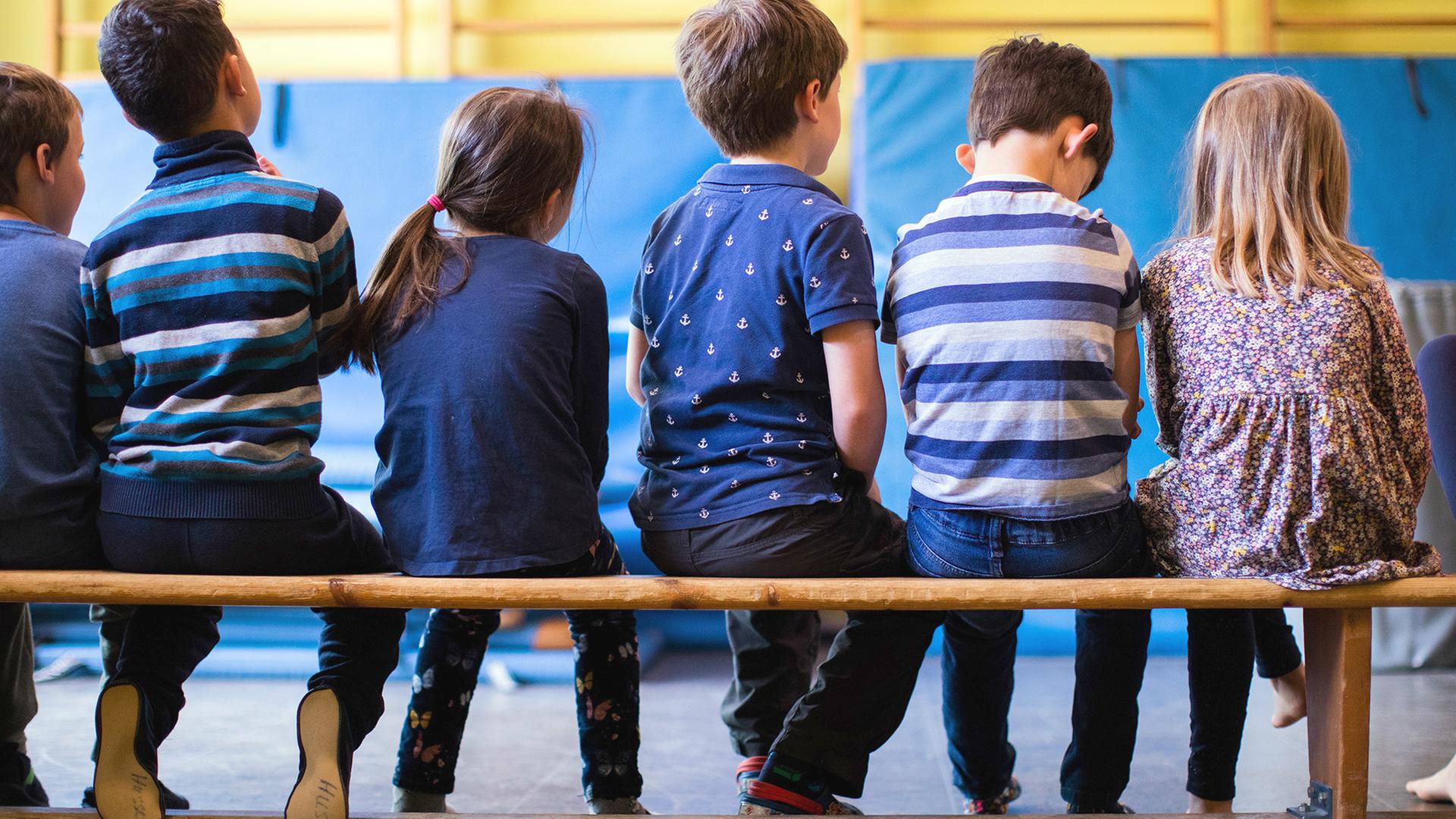 Kinder sitzen in einer Reihe | dpa