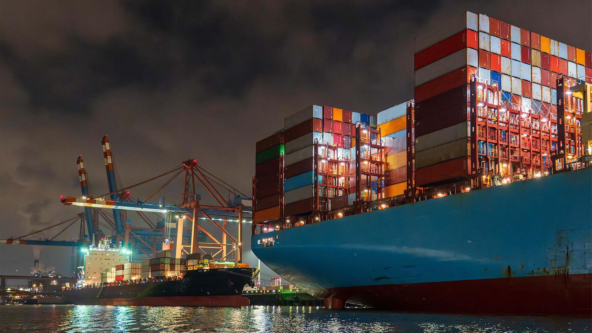 Containerschiffe im Hamburger Containerhafen bei Nacht. | picture alliance / Westend61