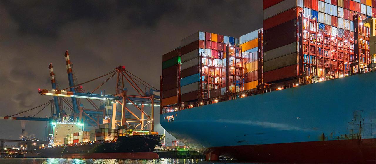 Containerschiffe im Hamburger Containerhafen bei Nacht.