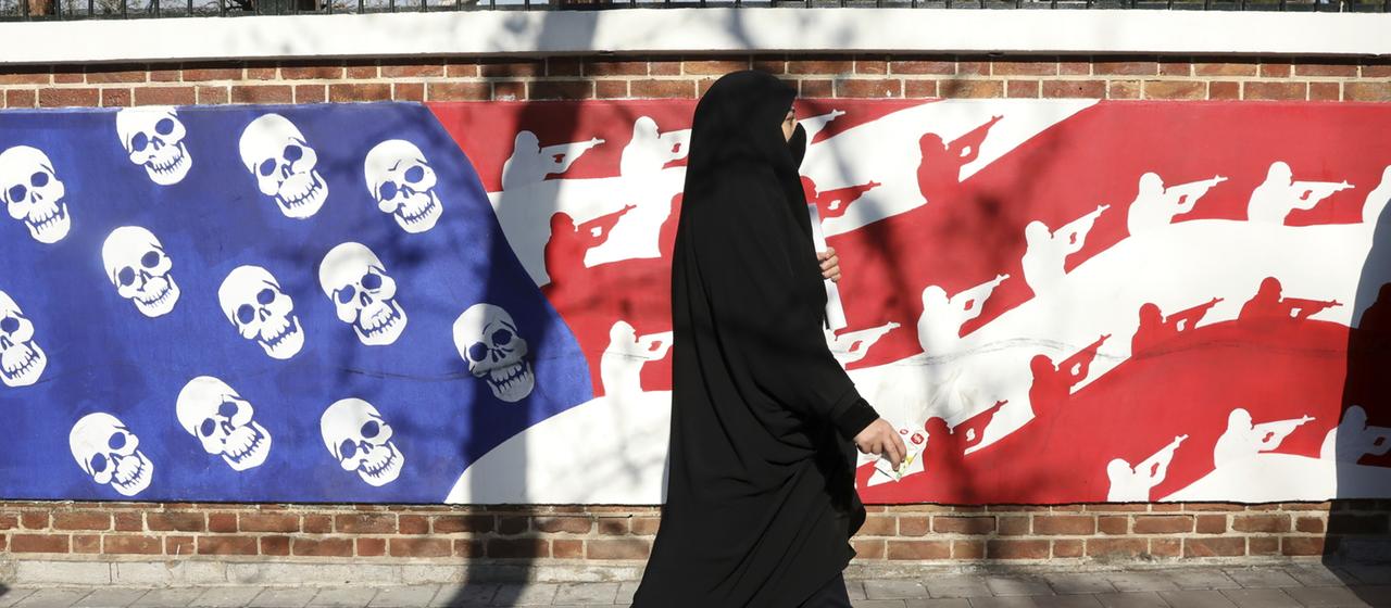 Eine Frau geht an einem anti-amerikanischen Wandbild in Teheran vorbei.