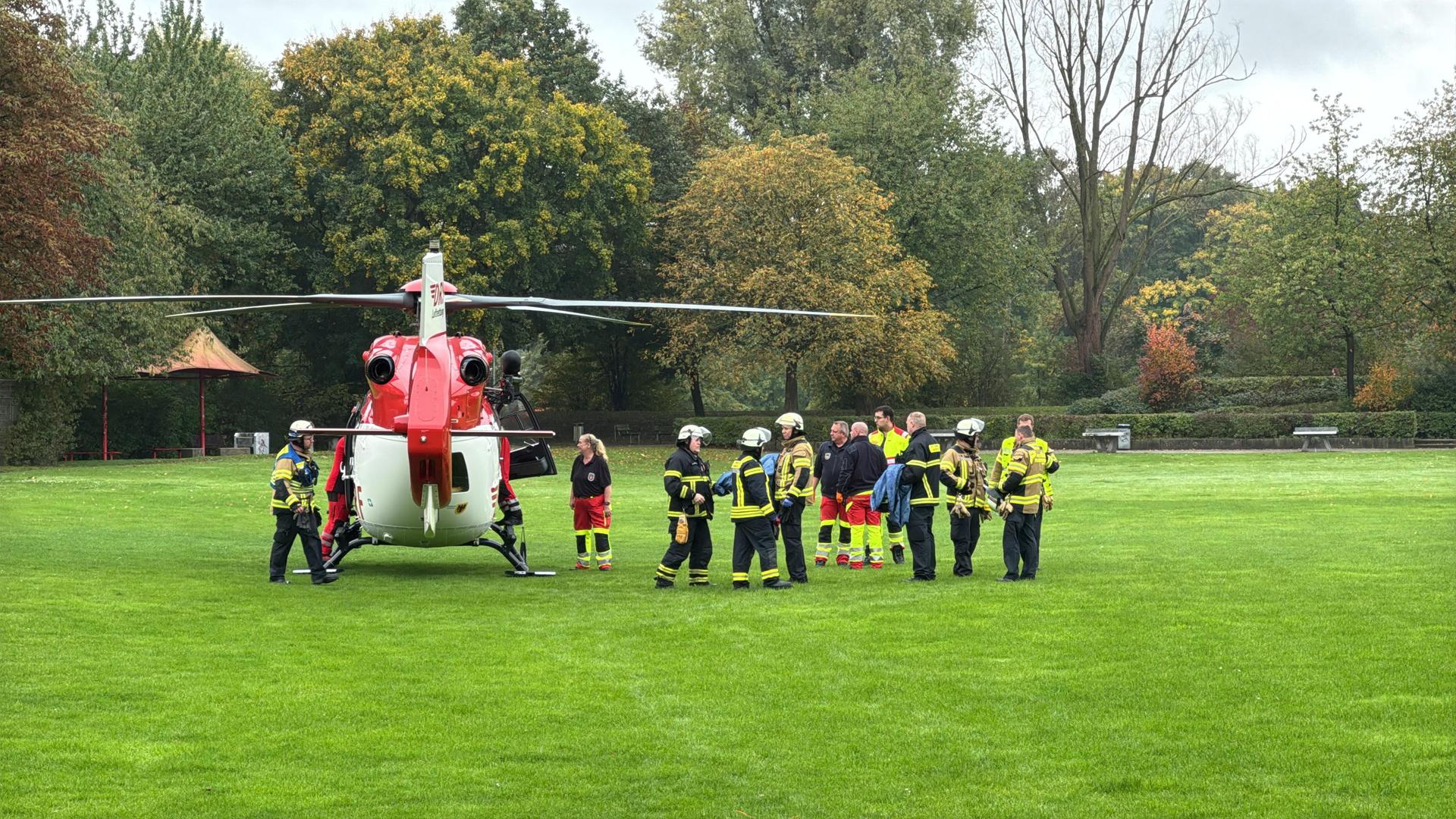 Ein Hubschrauber steht auf einer grünen Wiese, drumherum stehen Einsatzkräfte. | Alex Talash