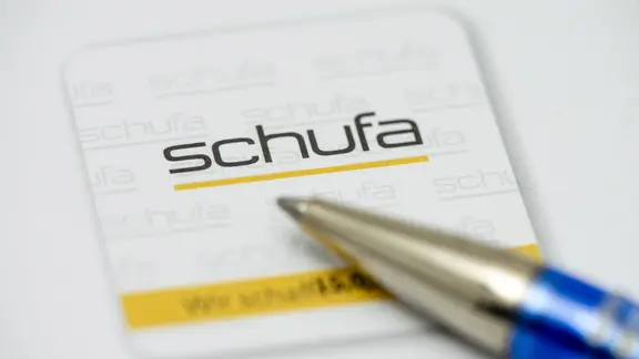 Die Schufa | Chromorange / newspixx vario images Ein Kugelschreiber liegt auf einem Formular der Schufa