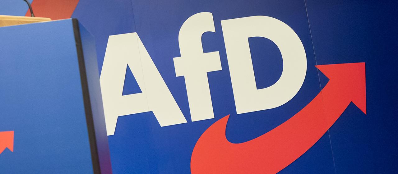 Das Logo der AfD ist hinter einem Rednerpult zu sehen.