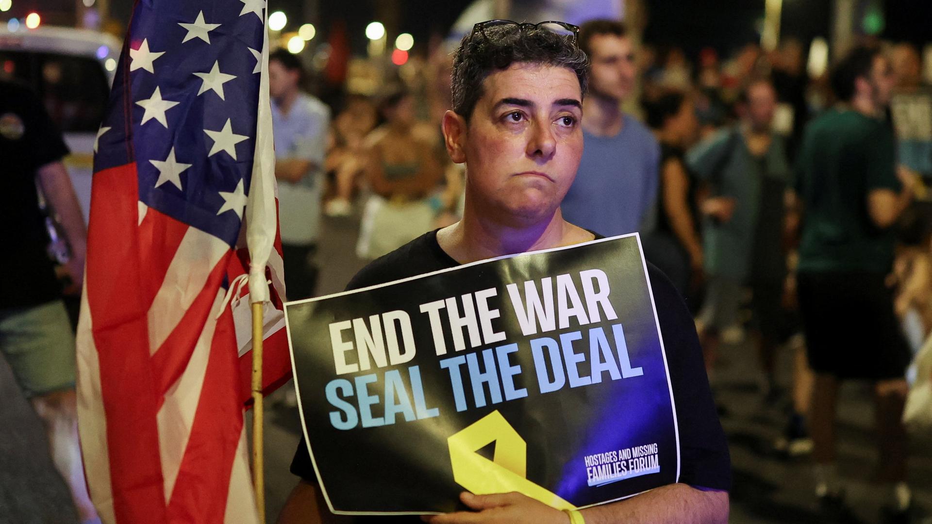 Demonstranten ziehen mit Plakaten durch Tel Aviv, auf denen sie ein Ende des Krieges und einen Deal zur Freilassung der Geiseln fordern. | REUTERS