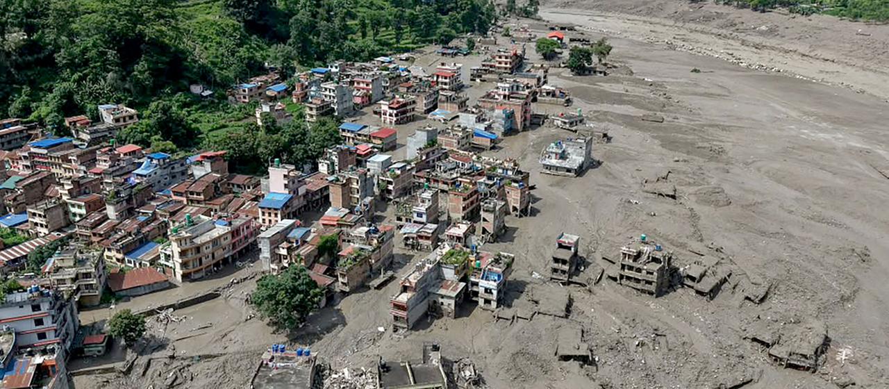 Nach Sturzfluten im nepalesischen Trishuli Bazar stehen Häuser am Flussufer teilweise im Schlamm.