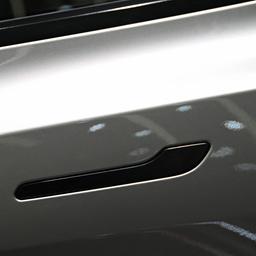 Eine Frau öffnet in einem Showroom in Peking die Tür eines Elektrofahrzeugs vom Typ Tesla Model YL.