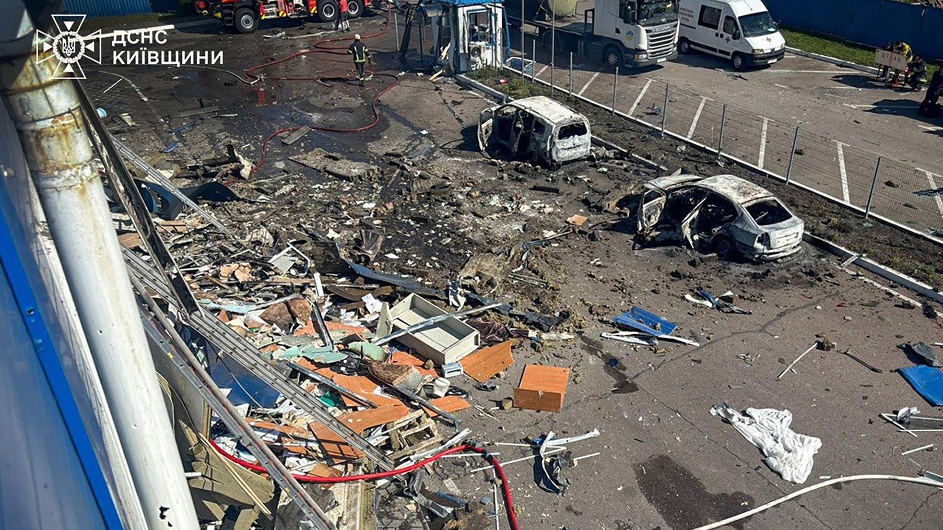 Rettungskräfte arbeiten zwischen Trümmern und ausgebrannten Autos. | AFP PHOTO / UKRAINIAN EMERGENCY SERVICE