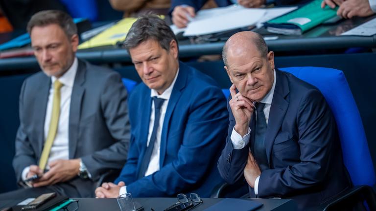 Christian Lindner sitzt neben Robert Habeck und Olaf Scholz auf der Regierungsbank im Bundestag. 