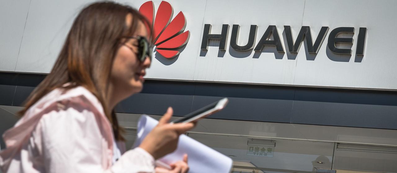 Was bedeuten die Maßnahmen für Verbraucher? | ROMAN PILIPEY/EPA-EFE/REX Frau mit Smartphone vor Huawei-Geschäft