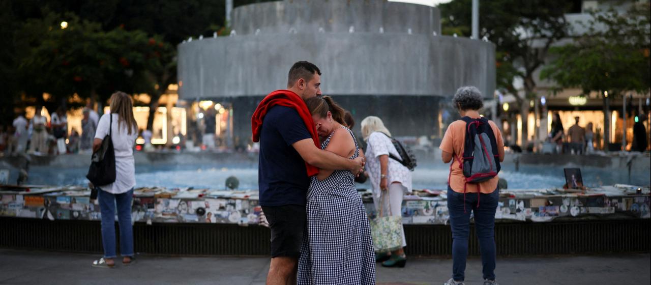 Ein Mann und eine Frau umarmen sich vor einem Brunnen in Tel Aviv am 7. Oktober 2026.