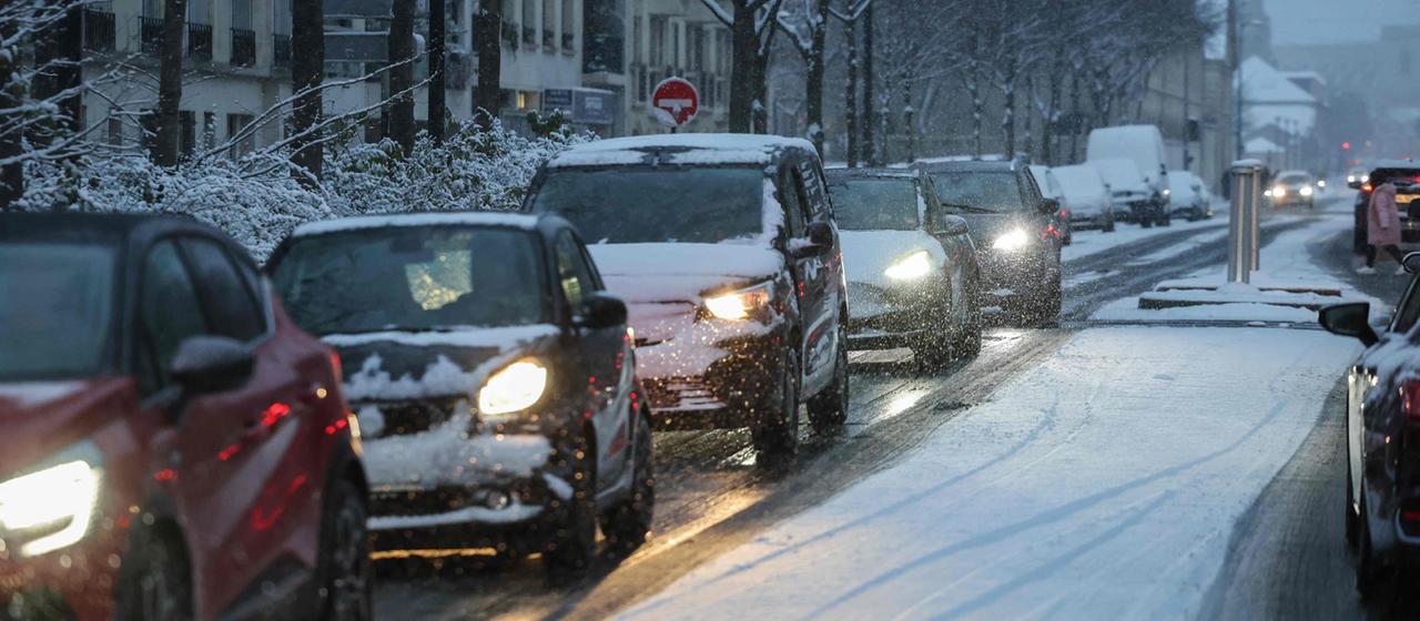 Autos fahren bei Schneefall durch Paris, Frankreich.