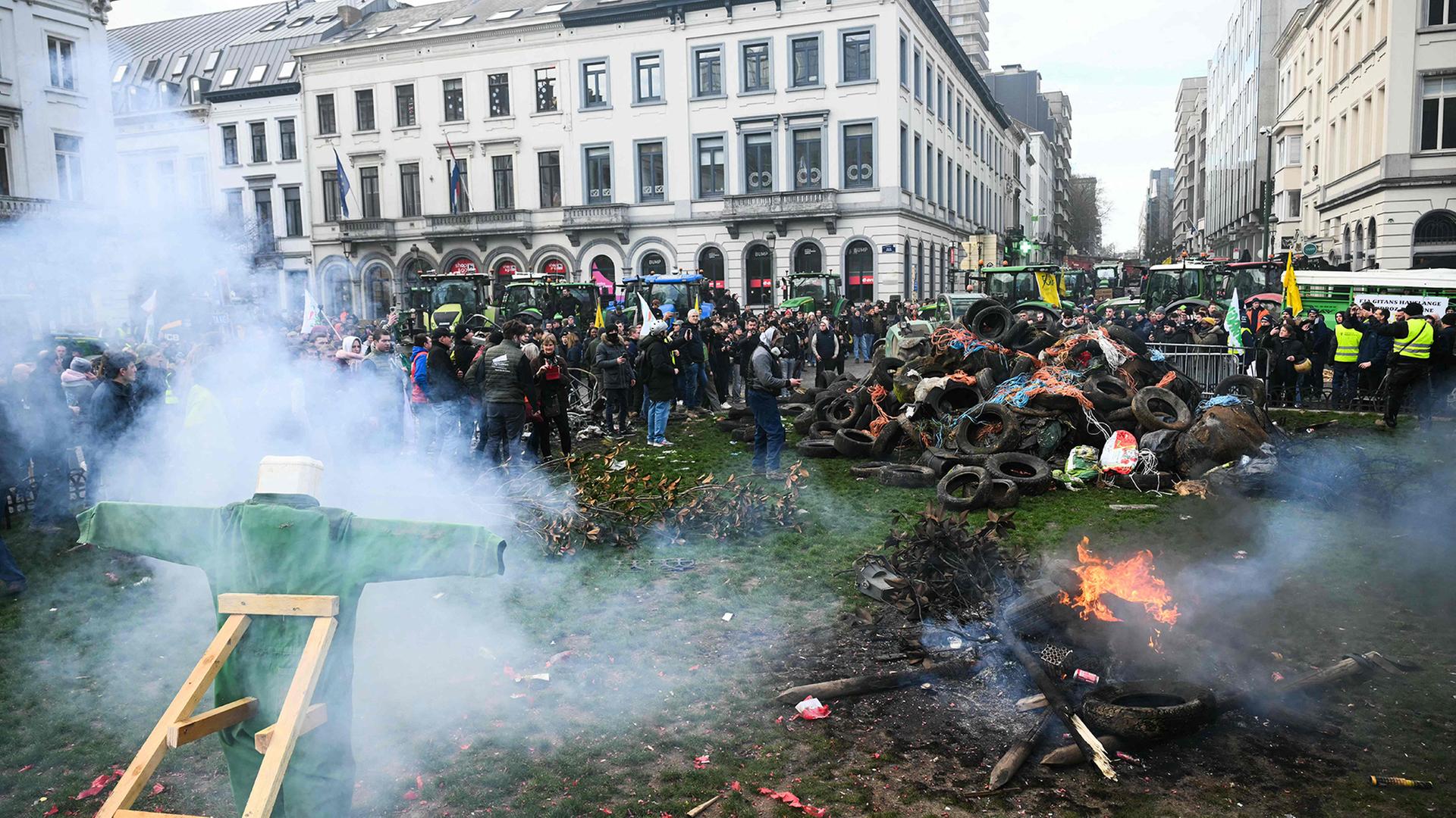 Protestierende Landwirte stehen neben Traktoren und einem Feuer in der N�he des Europ�ischen Parlaments auf der Place du Luxembourg in Br�ssel. | AFP