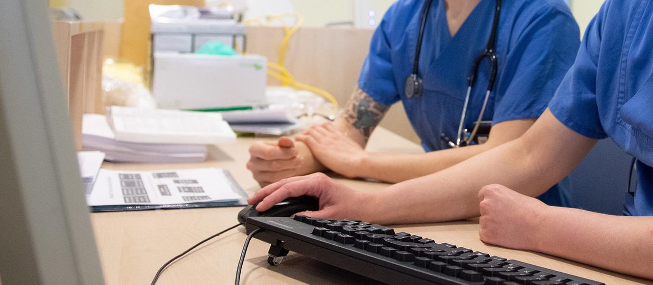 Ärzte sitzen vor einem Computerbildschirm. 