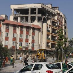 Menschen versammeln sich vor einem beschädigten Gebäude in der iranischen Hauptstadt Teheran.