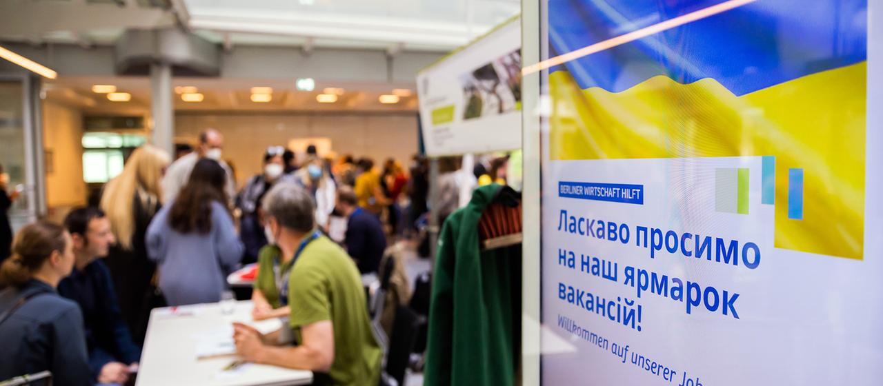 Auf einer Jobmesse für ukrainische Flüchtlinge unterhalten sich Menschen
