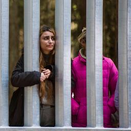 Migranten sind auf der belarusischen Seite der polnischen Grenzmauer in Bialowieza zu sehen.