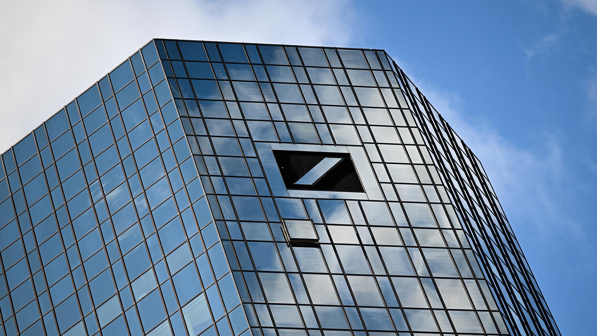 Wolken spiegeln sich in der Glasfassade der Zwillingstürme der Zentrale der Deutschen Bank. | dpa