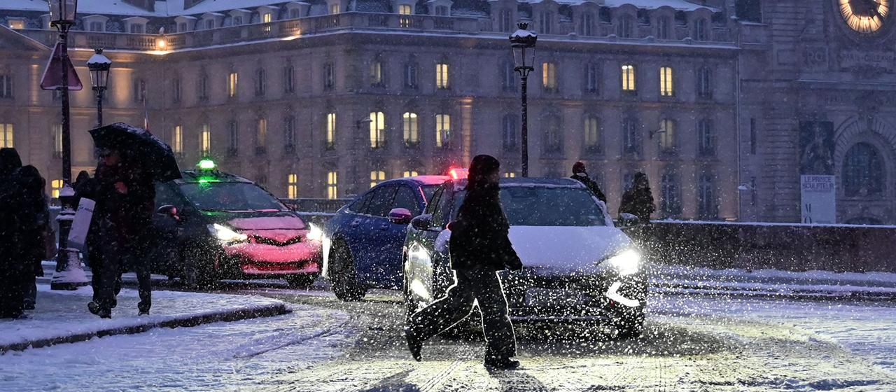 Ein Fußgänger überquert eine mit Schnee bedeckte Straße in der Nähe von Point Royal in Paris.