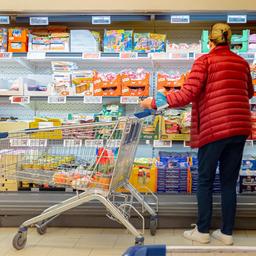 Kundin vor einem Kühlregal in einem Supermarkt.
