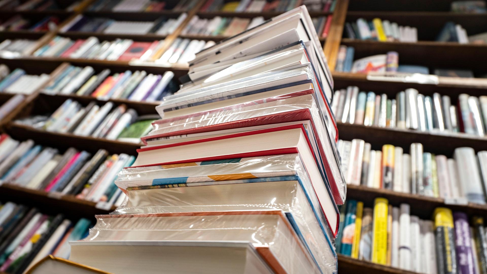 Ein Stapel Bücher liegt auf einem Verkaufstisch in einer Buchhandlung. | picture alliance/dpa