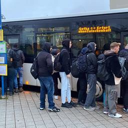Menschen in der Dämmerung vor Bus